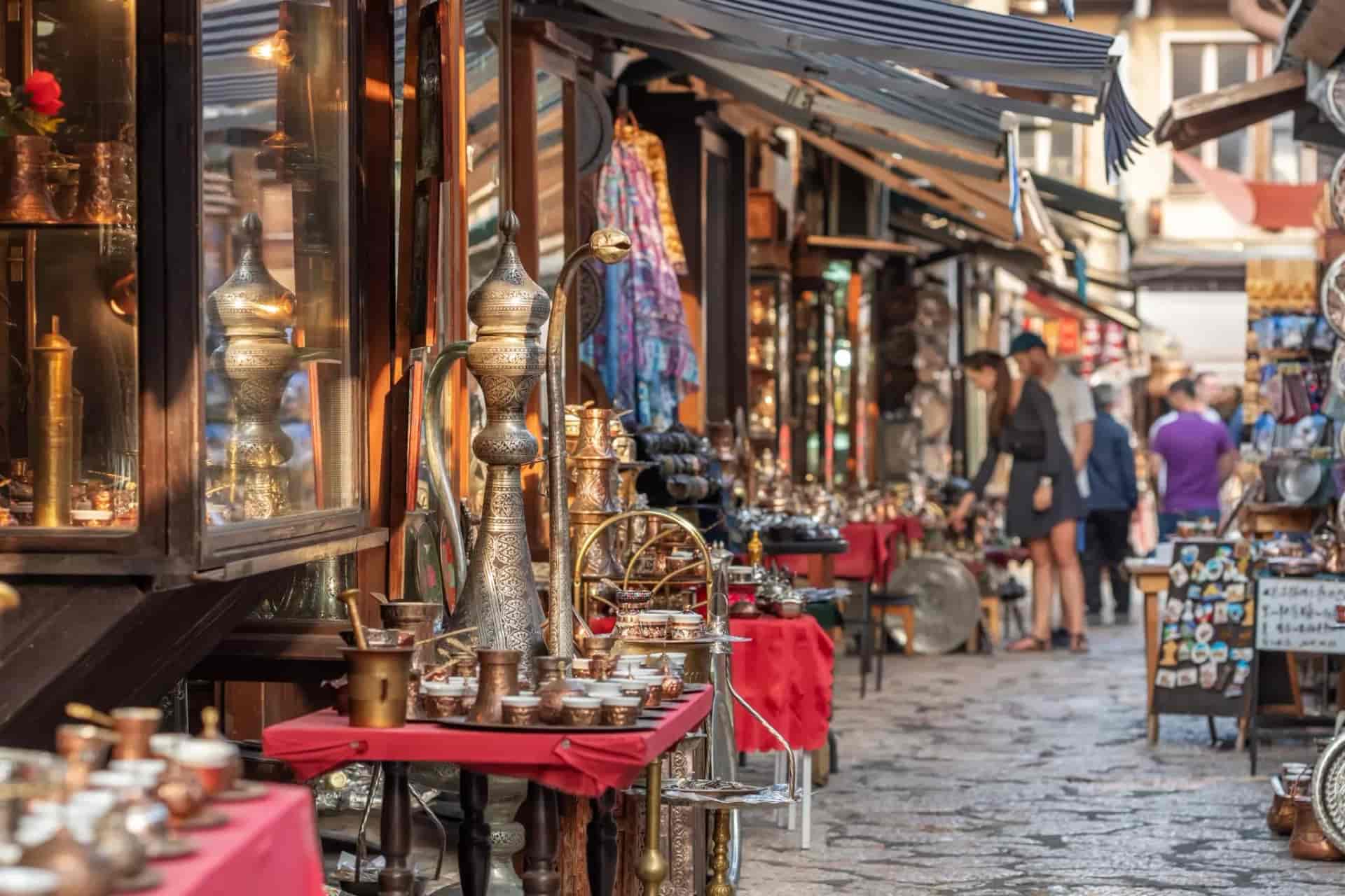 Metalwork and coffee sets displayed at street stalls in Sarajevo's Bascarsija market.