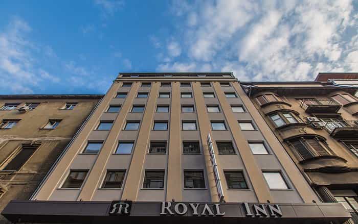 Royal Inn hotel facade looking up at blue sky with clouds in Belgrade, Serbia