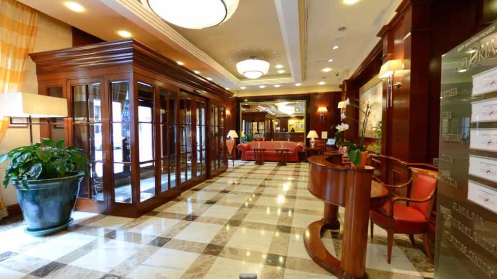 Best Western Premier Hotel Astoria lobby with polished marble floor and dark wood paneling.