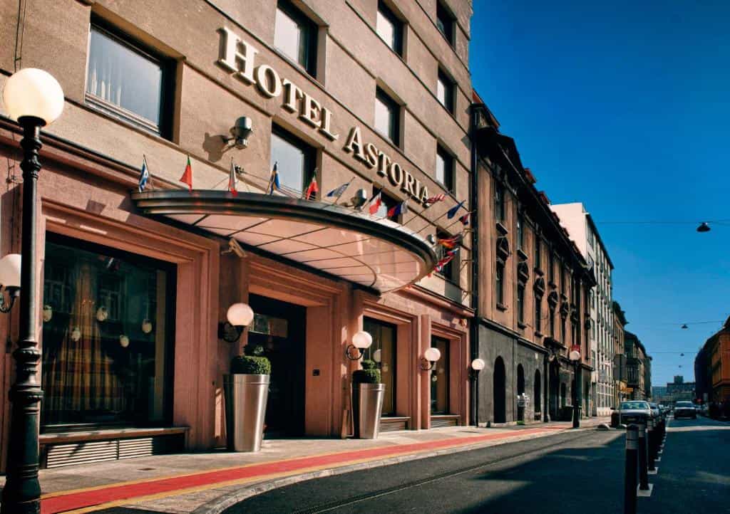 Best Western Premier Hotel Astoria entrance with flags under a clear blue sky