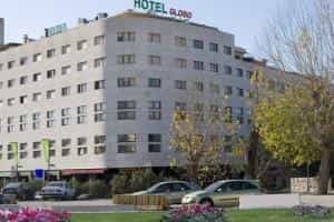 Hotel Globo building facade with parked cars and small trees in the foreground.
