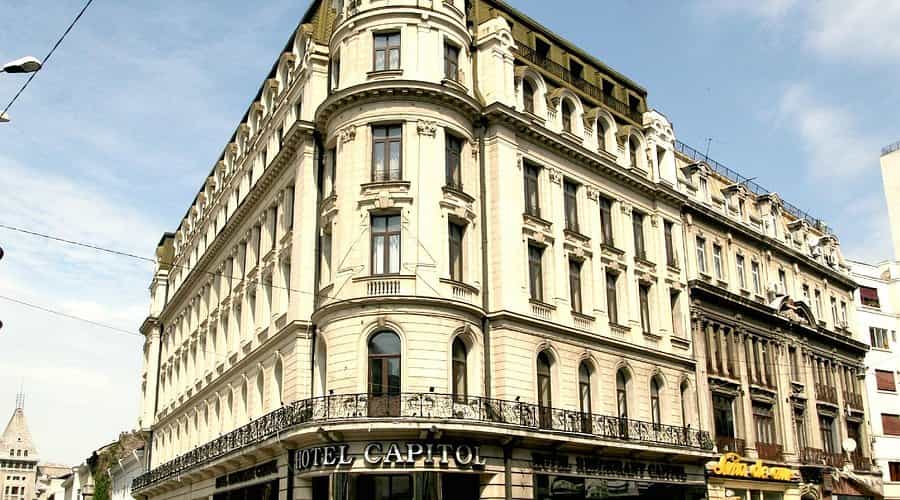 Hotel Capitol building facade with ornate balconies under a blue sky in a city setting.