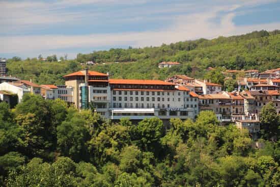 Hotel Grand in Veliko Tarnovo nestled among green hills and traditional town buildings.