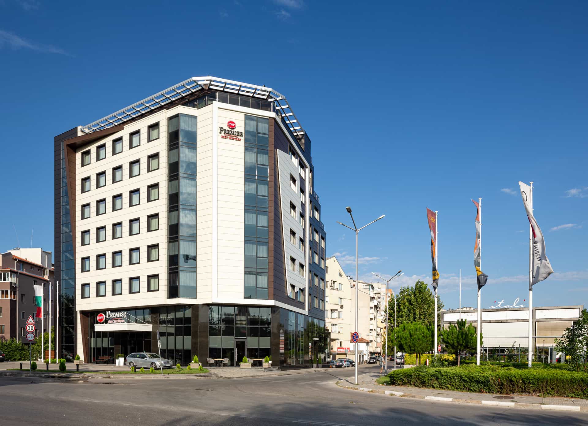 Best Western Premier Plovdiv Hills hotel exterior on a sunny day with flags flying.