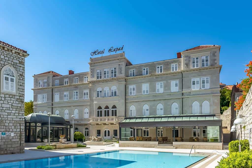 Hotel Lapad building with outdoor swimming pool on a sunny day