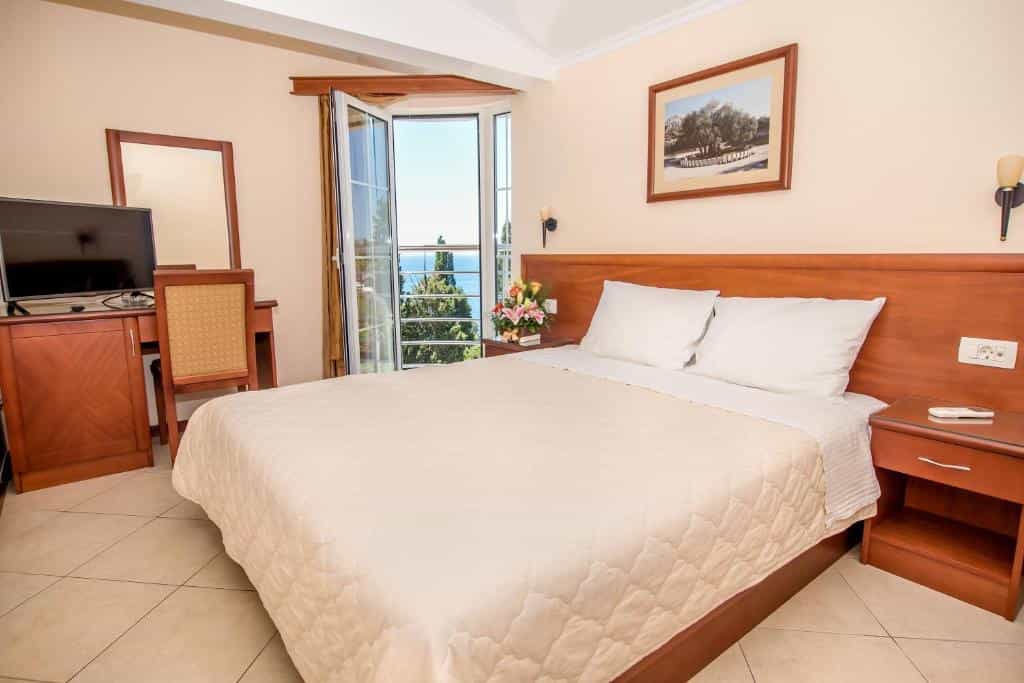Hotel room with double bed, balcony view of sea and trees, Villa Antivari.