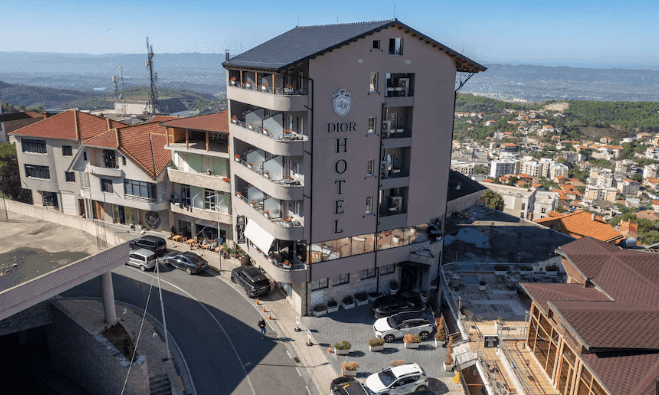 Dior Hotel building in Krujë with surrounding town and distant green hills.