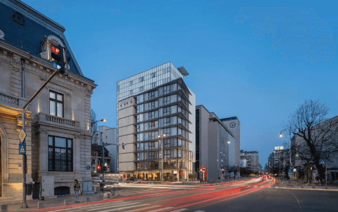 Hotel Leonardo Bucharest City Center exterior at dusk with light trails from traffic.