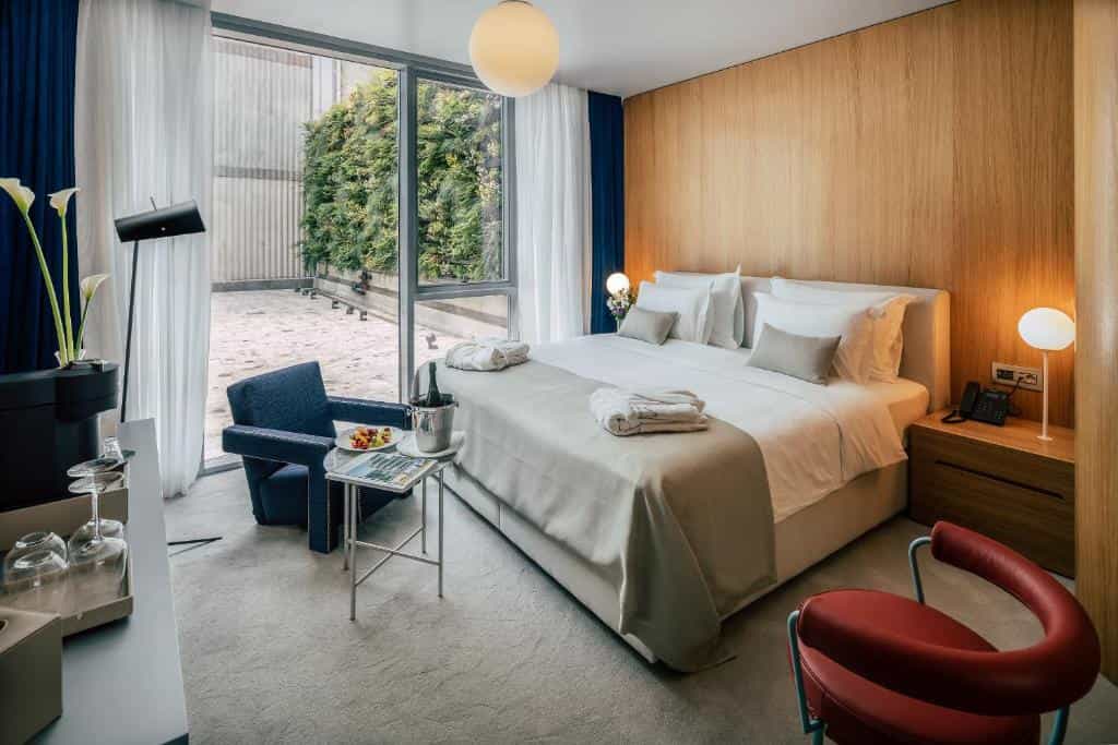 Boutique hotel bedroom with large bed, modern decor, and patio view in Zagreb.
