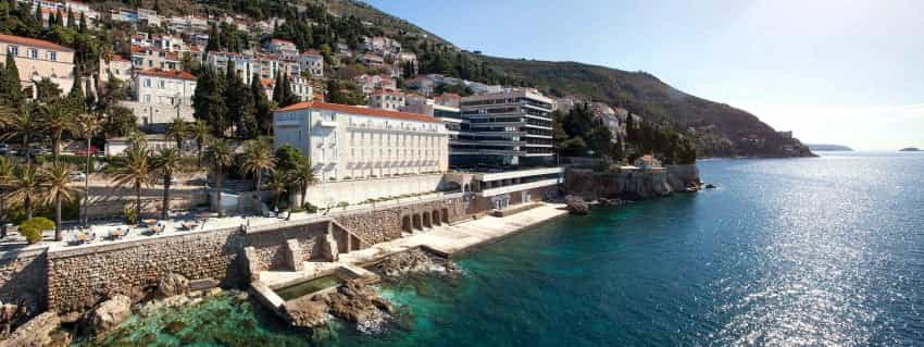 Hotel Excelsior Dubrovnik on the Adriatic Sea with terraced seating and clear blue water.