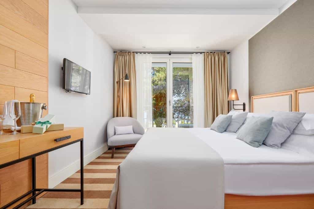 Hotel room with large bed, balcony view, and welcome champagne bucket.