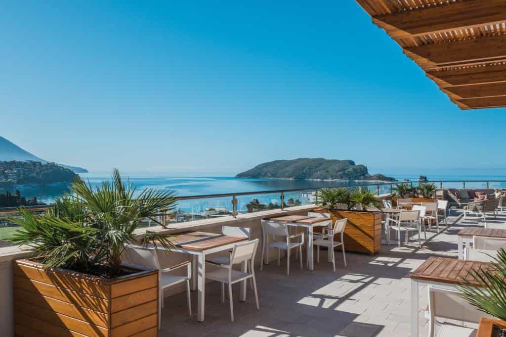 Outdoor terrace dining area overlooking the sea and island, likely in Slavija/Iberostar area.