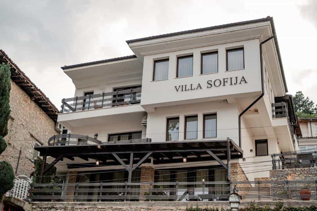 White Villa Sofija building next to stone structure under cloudy sky in Ohrid