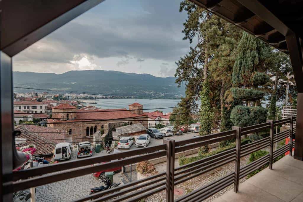 View from balcony over Ohrid town, lake, and mountains under cloudy sky
