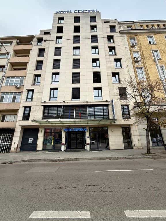Hotel Central building facade on city street with surrounding older buildings and bare tree.