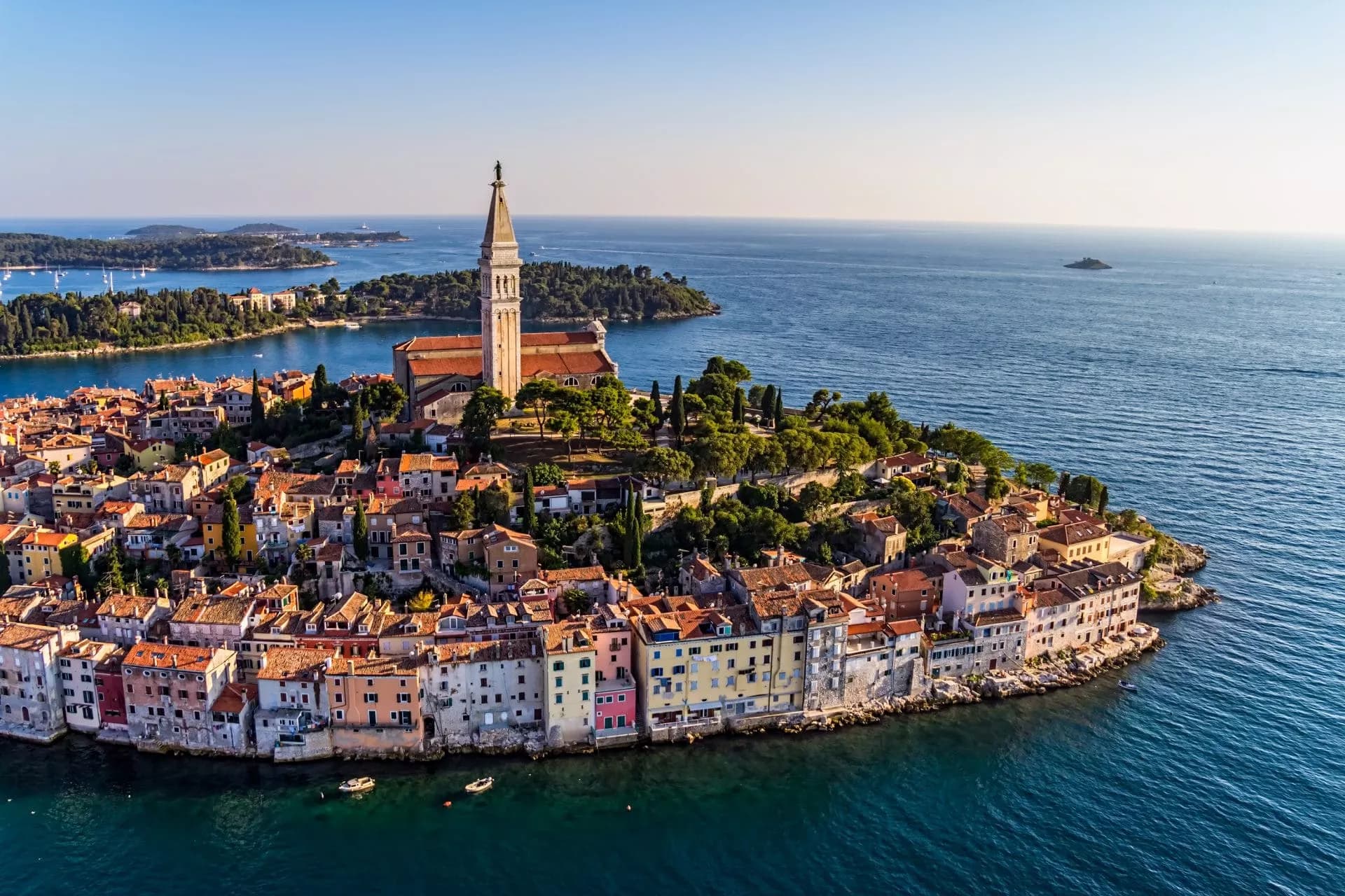 Rovinj town in Croatia with colorful buildings clustered around a peninsula and a tall church tower overlooking the Adriat...