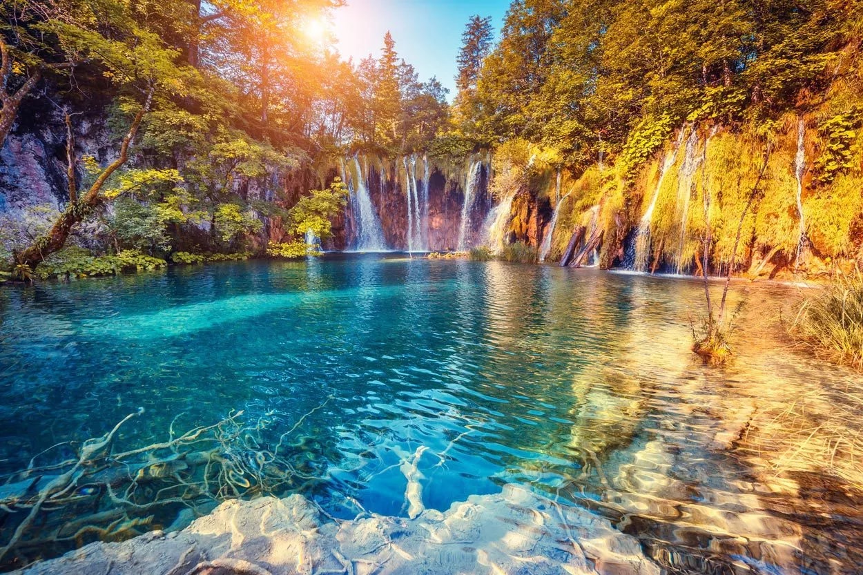 Plitvice Lakes waterfalls cascading into turquoise pools surrounded by autumn foliage