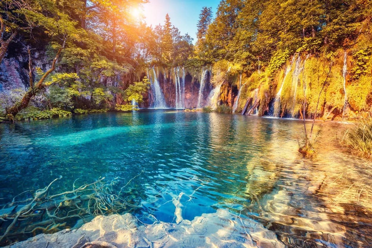 Plitvice Lakes waterfalls cascading into turquoise pools surrounded by autumn foliage