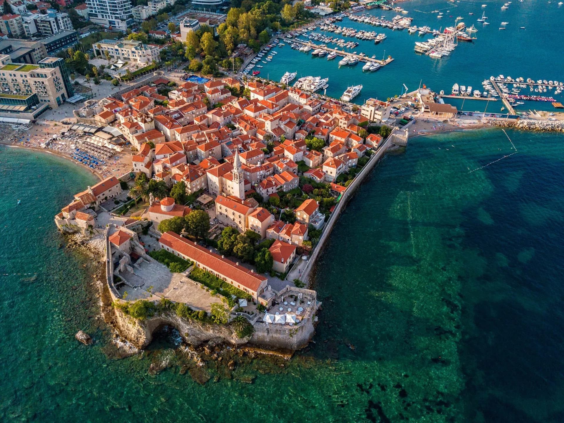 Aerial view of Budva, the old city (stari grad) of Budva, Montenegro. Jagged coast on the Adriatic Sea. Center of Montenegrin tourism, well-preserved medieval walled city, sandy beaches