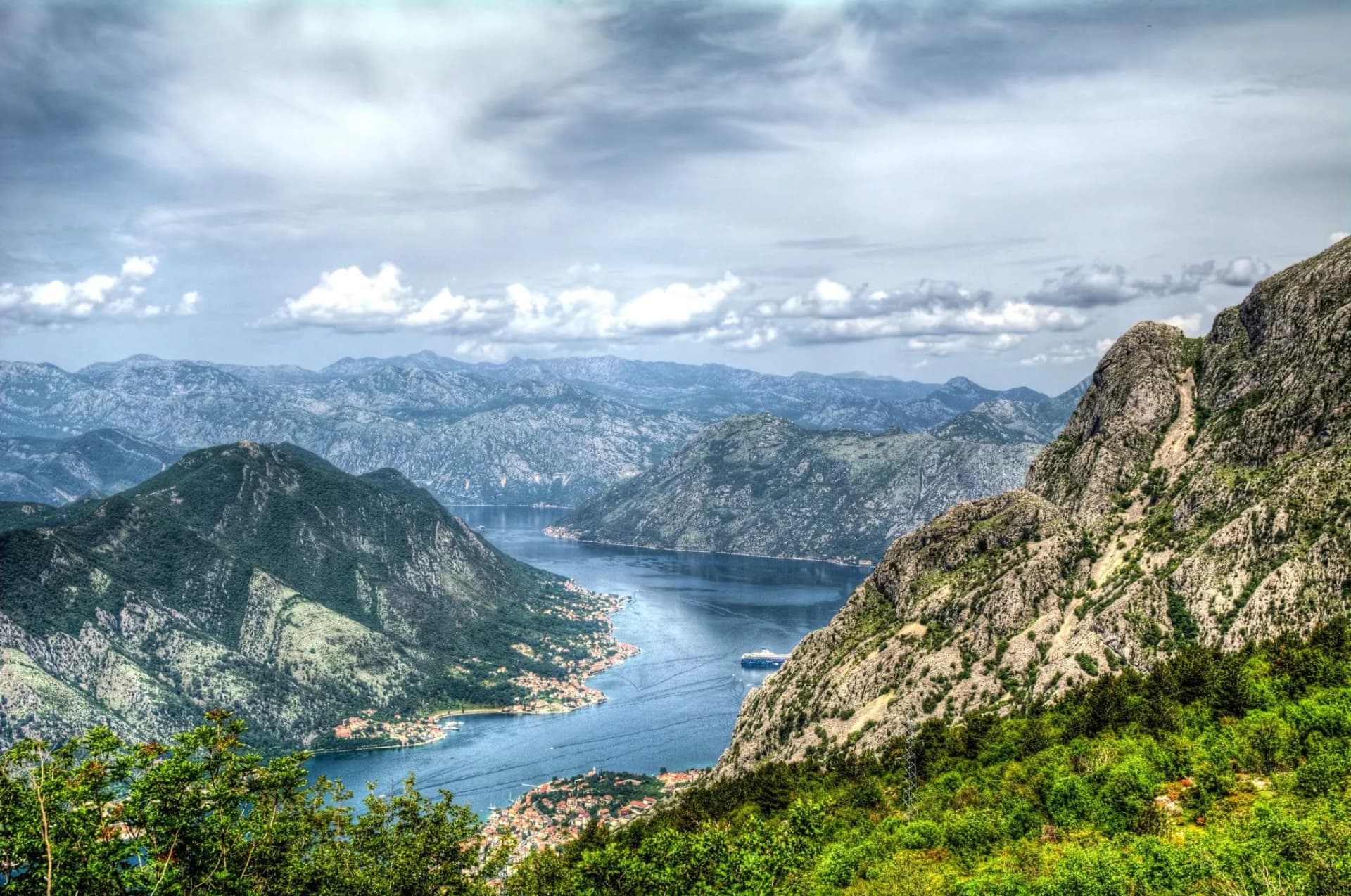Bay of Kotor view from Lovcen showing steep mountains, a fjord, and a cruise ship.