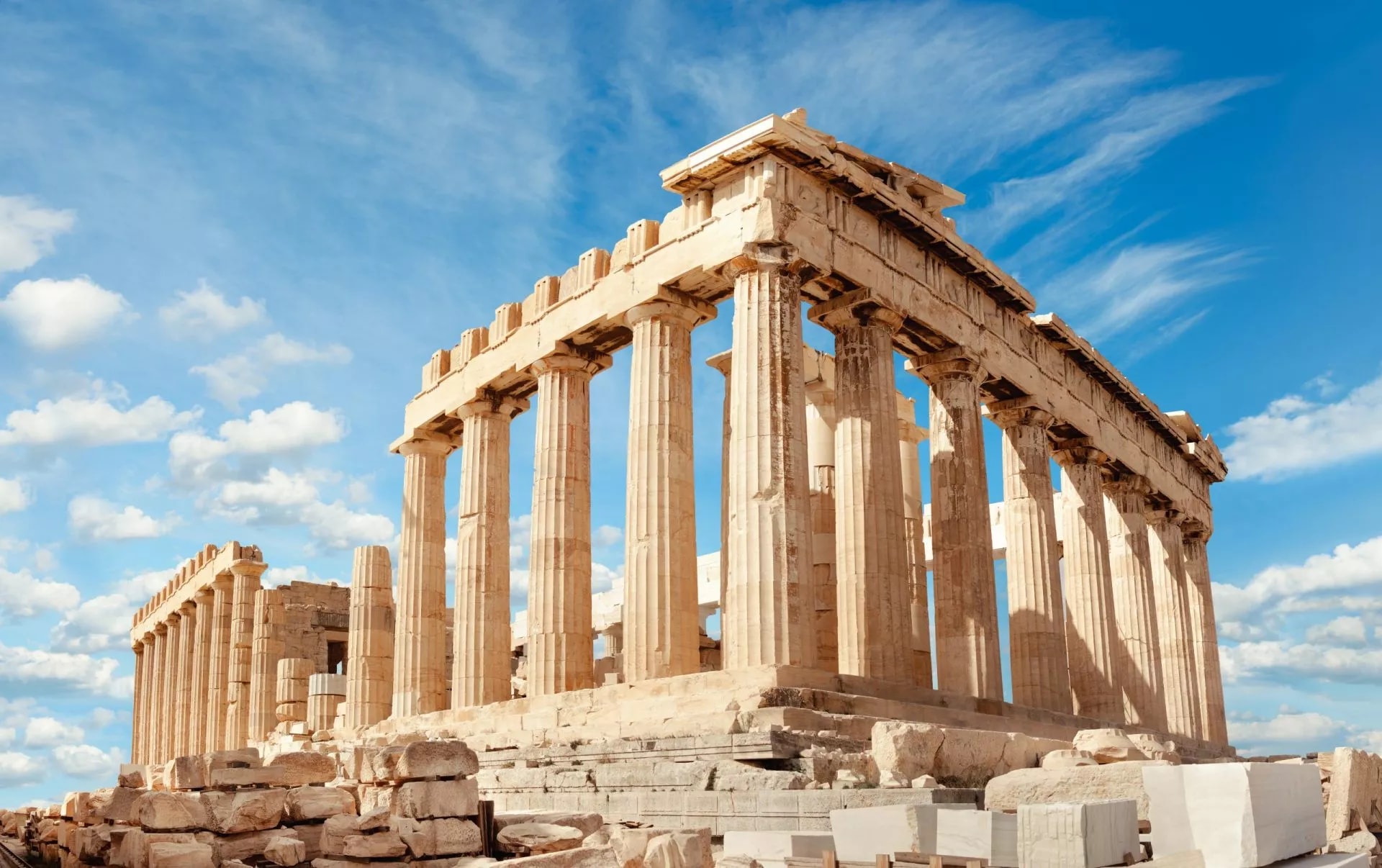 Parthenon temple ruins on the Acropolis in Athens, Greece, under a blue sky.