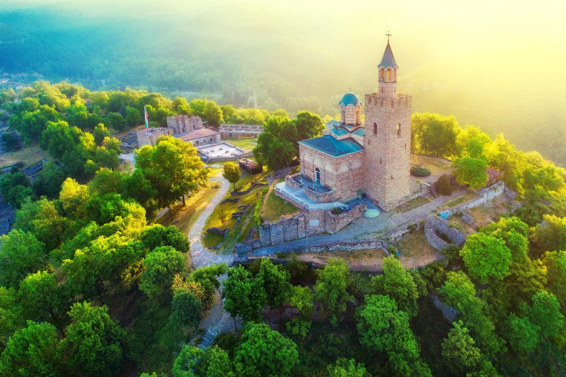 Aerial view of Tsarevets Fortress and church on a hill in Veliko Tarnovo, Bulgaria, during a sunny summer morning.