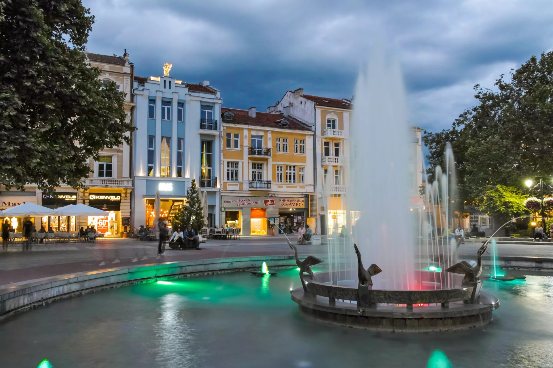 Night photo of illuminated fountain with bird sculptures on Plovdiv walking street, Bulgaria.