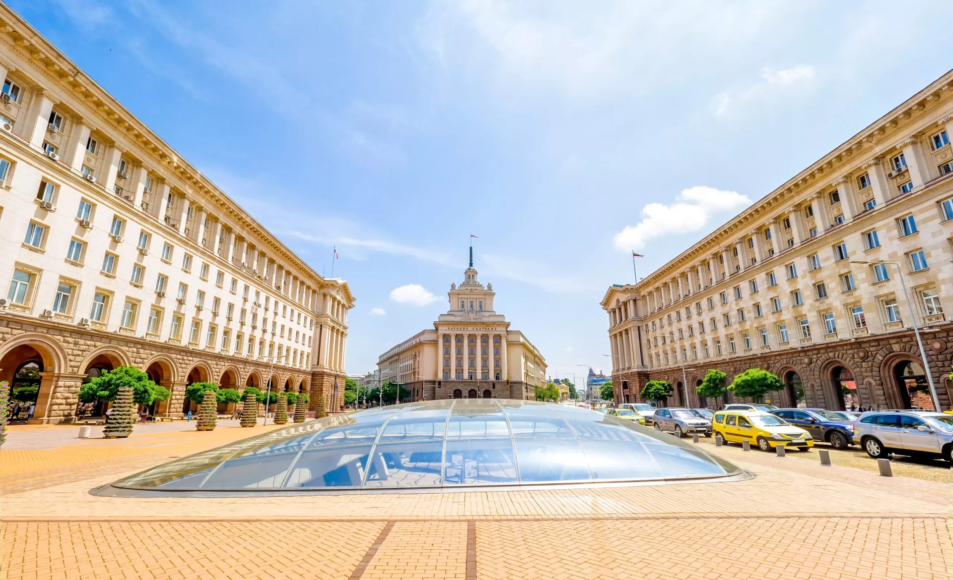 National Assembly Building in Sofia, Bulgaria, with glass dome entrance on a sunny day.