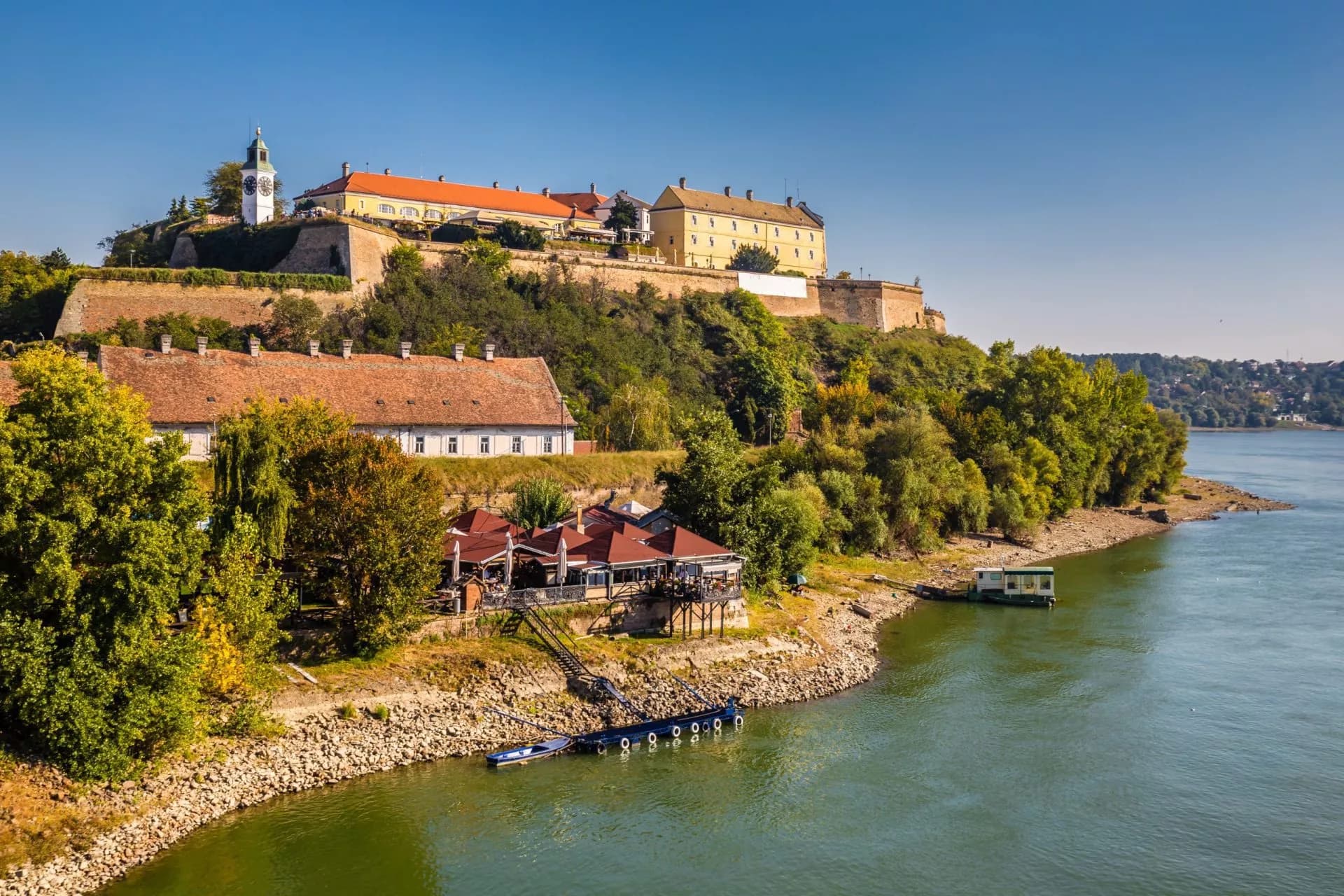 Petrovaradin Fortress overlooking Novi Sad and the Danube River with riverside buildings.