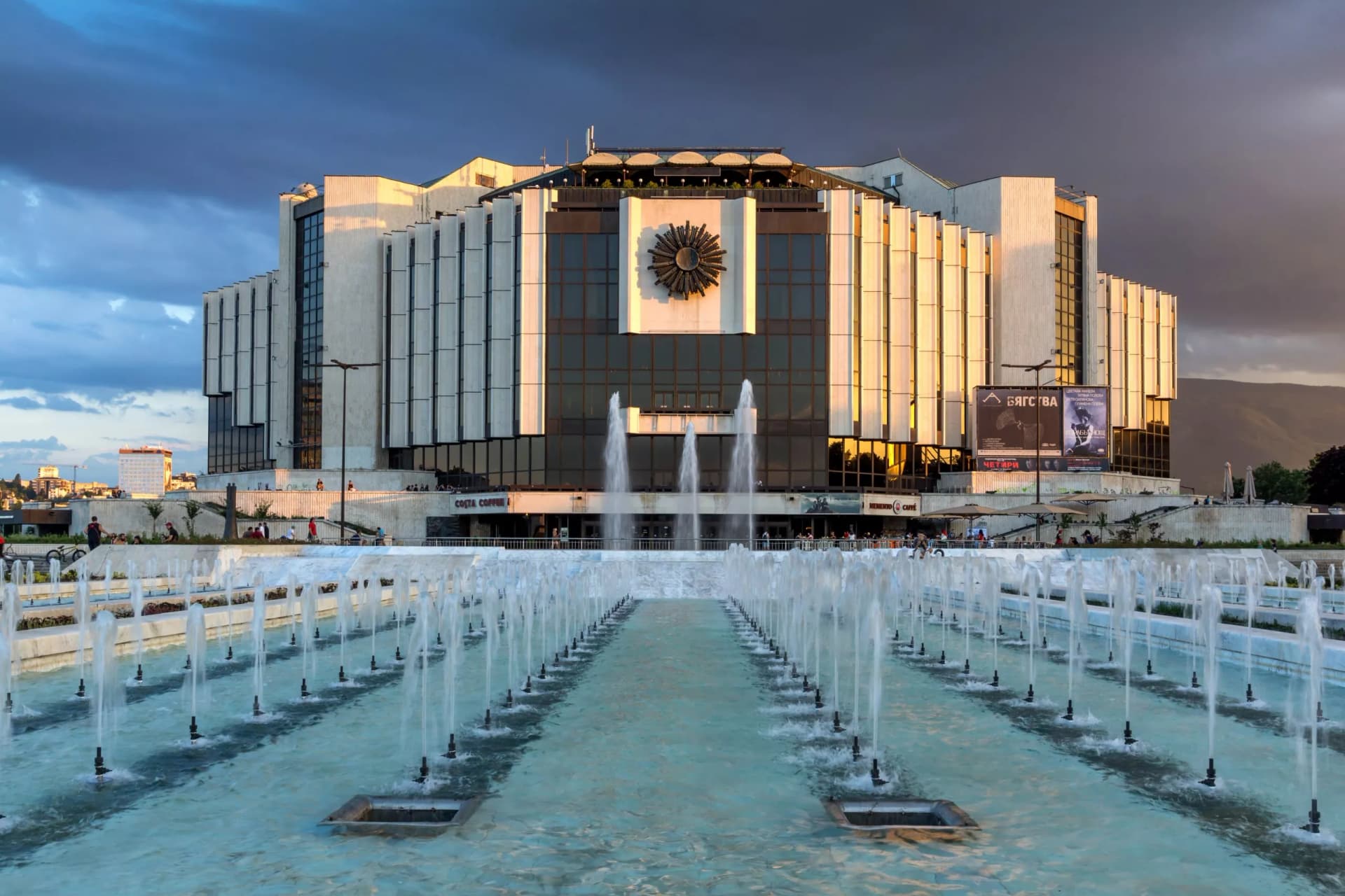 Sunset view of National Palace of Culture in Sofia, Bulgaria, with long fountains operating.