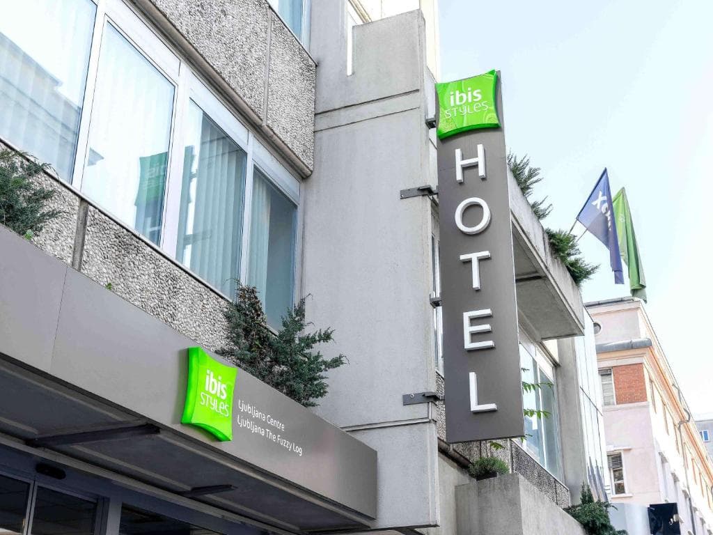 Ibis Styles Ljubljana Centre hotel exterior with vertical "HOTEL" sign and green logo.