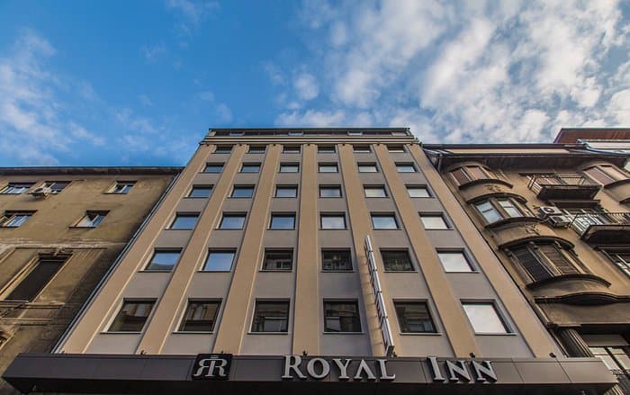 Royal Inn hotel facade looking up at blue sky with clouds in Belgrade, Serbia