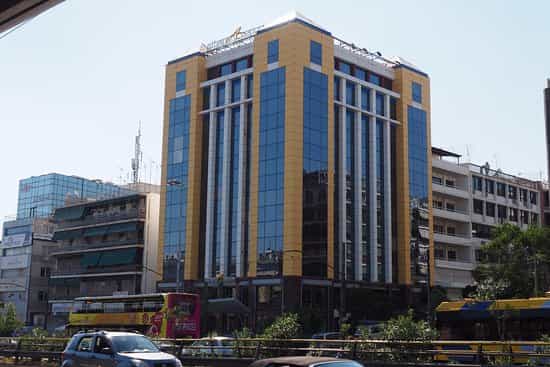 Athens Avenue Hotel building with yellow and blue glass facade on sunny city street